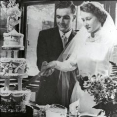 Margaret and Dig cutting their wedding cake.